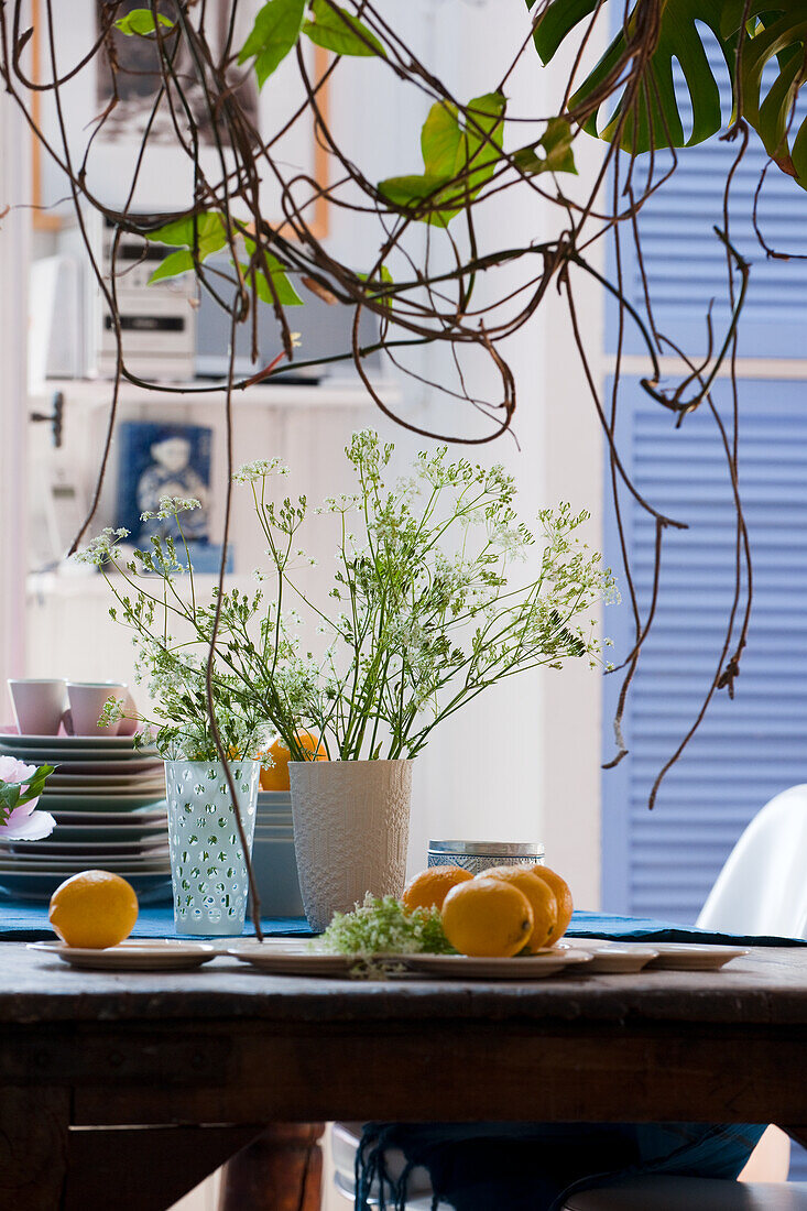 Table decoration with flower vases, crockery and lemons