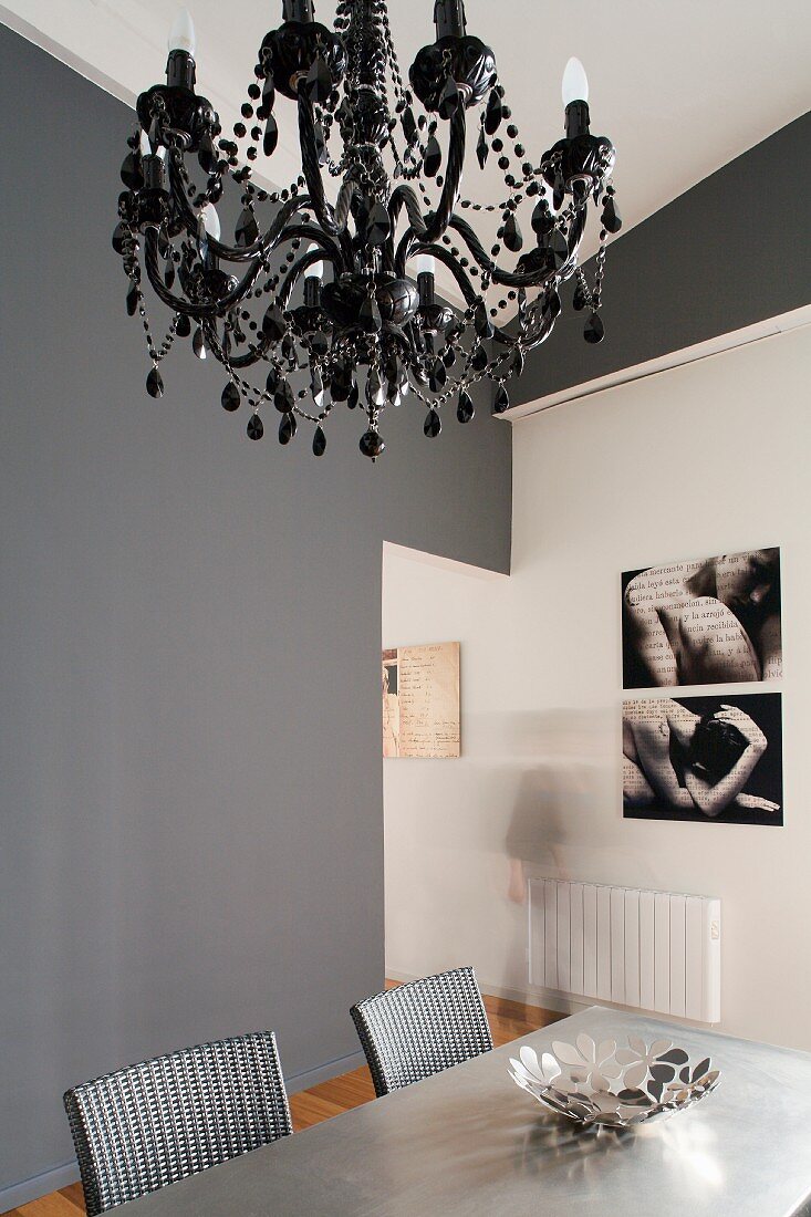Modern dining room- black chandelier above dining area in front of grey-painted wall