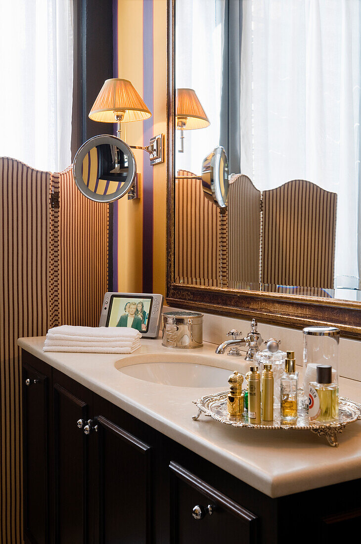 Washbasin with perfume bottles on a tray in a classic bathroom