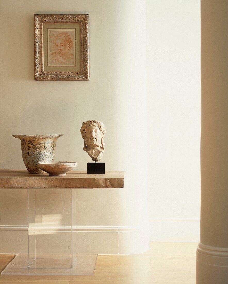 Antik griechischer Kopf aus Stein und Gefässe auf Tisch mit Steinplatte