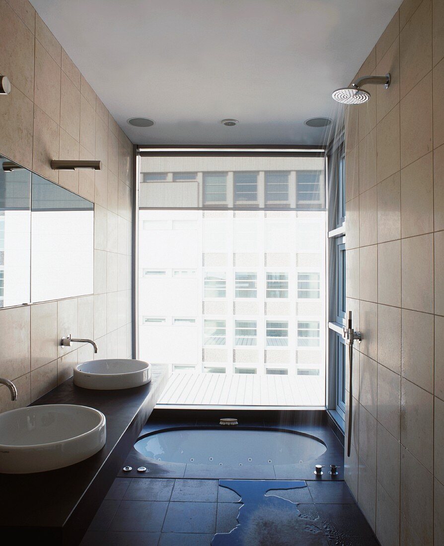 Modernes Bad mit im Boden eingelassener Badewanne vor raumhohem Fenster
