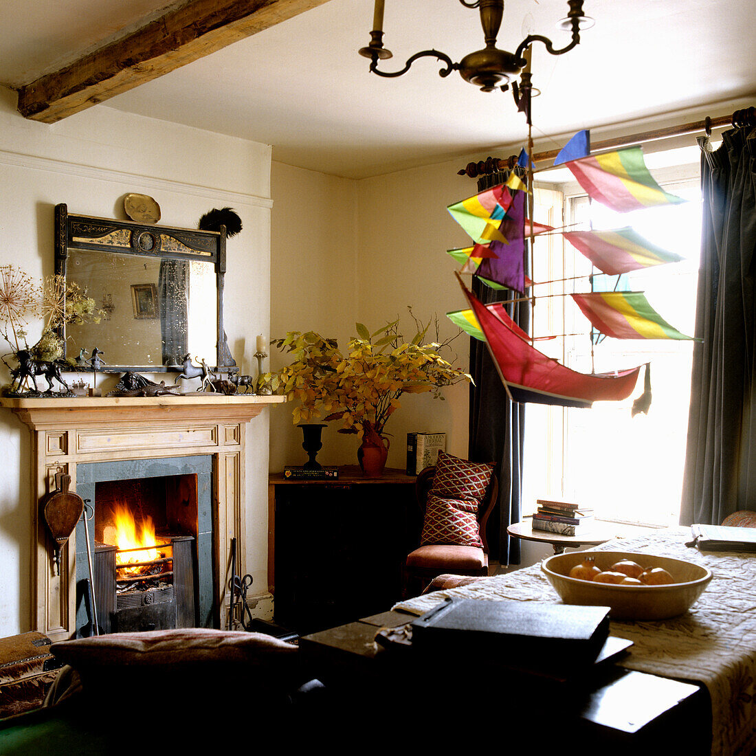 Living room with fireplace, sailing ship mobile and antique wooden furniture