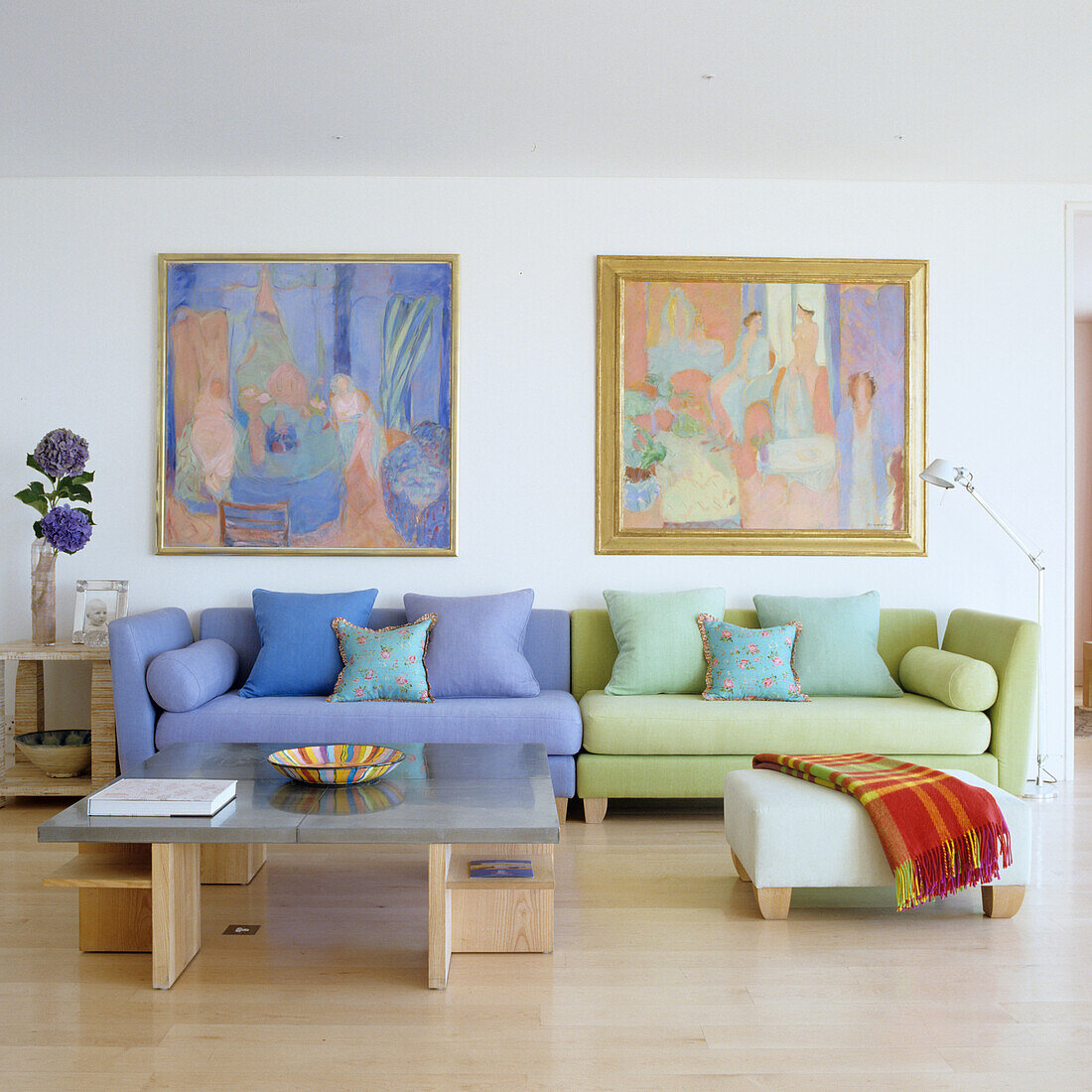 Helles Wohnzimmer mit blauem und grünem Sofa, Gemälde an der Wand