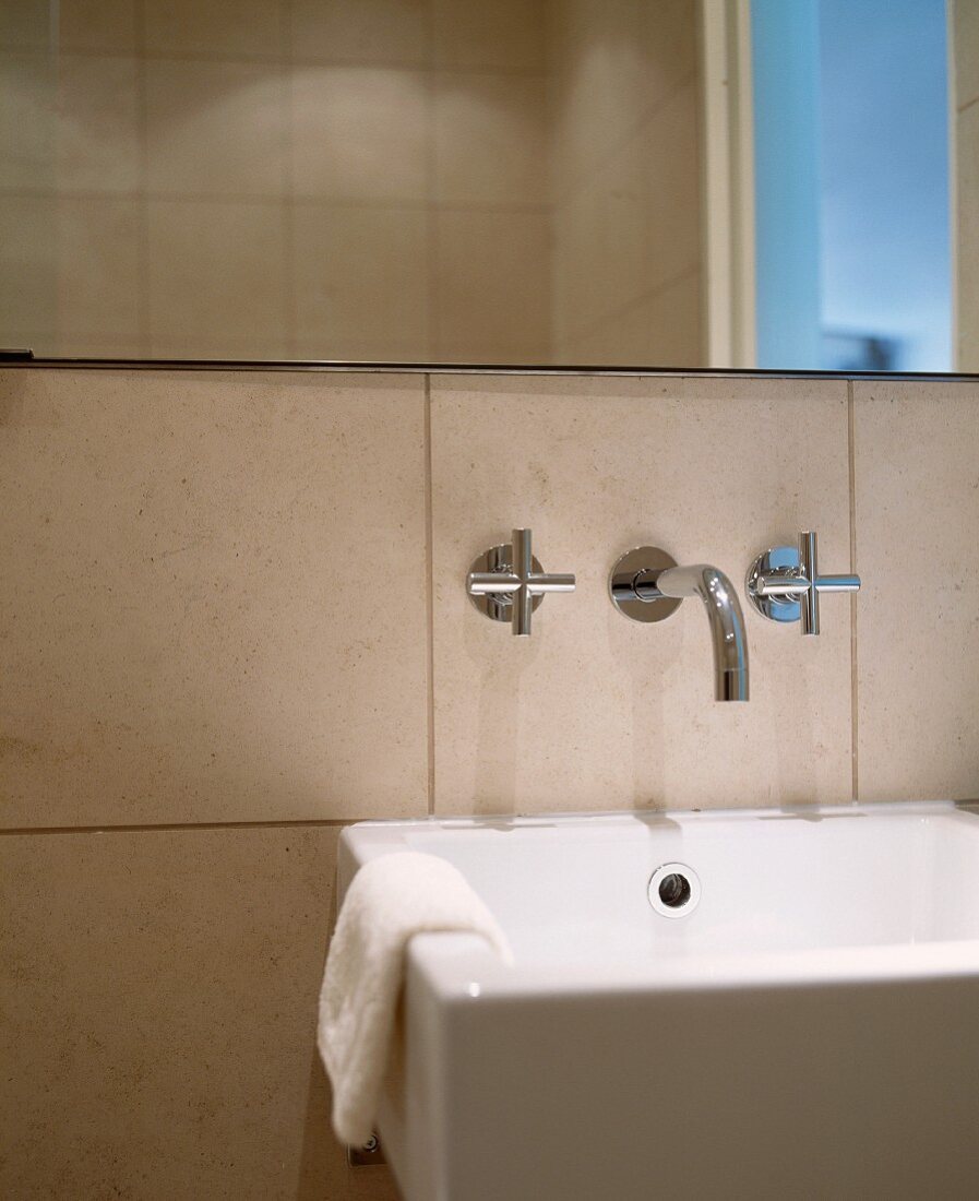 Bad mit modernem Waschtisch und Wandarmatur unter Spiegel