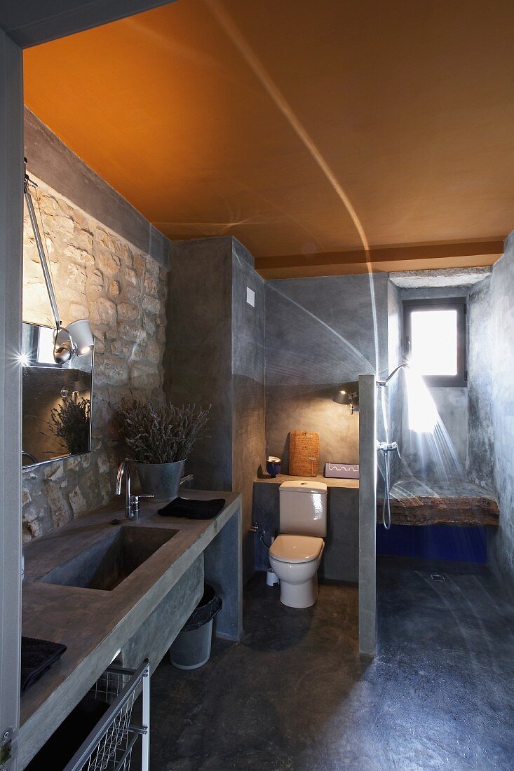 Rustic modern bathroom with stone walls and yellow-painted ceiling