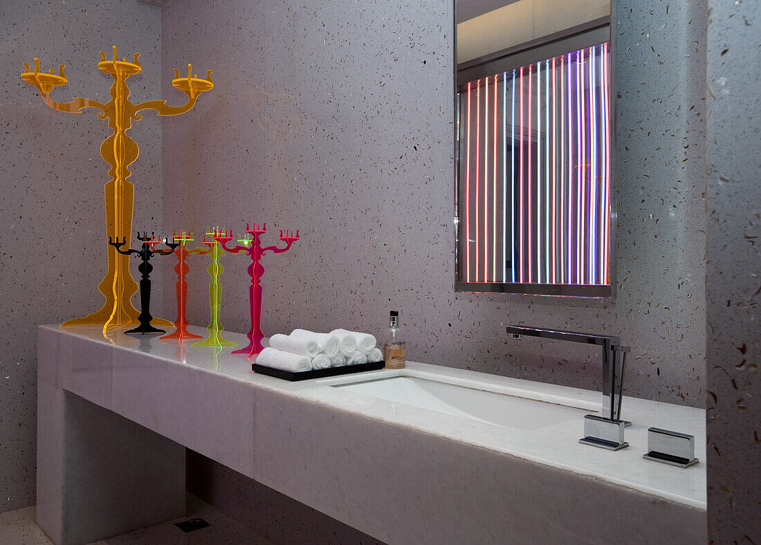 Modern bathroom furnishings with colourful candlesticks and terrazzo wall