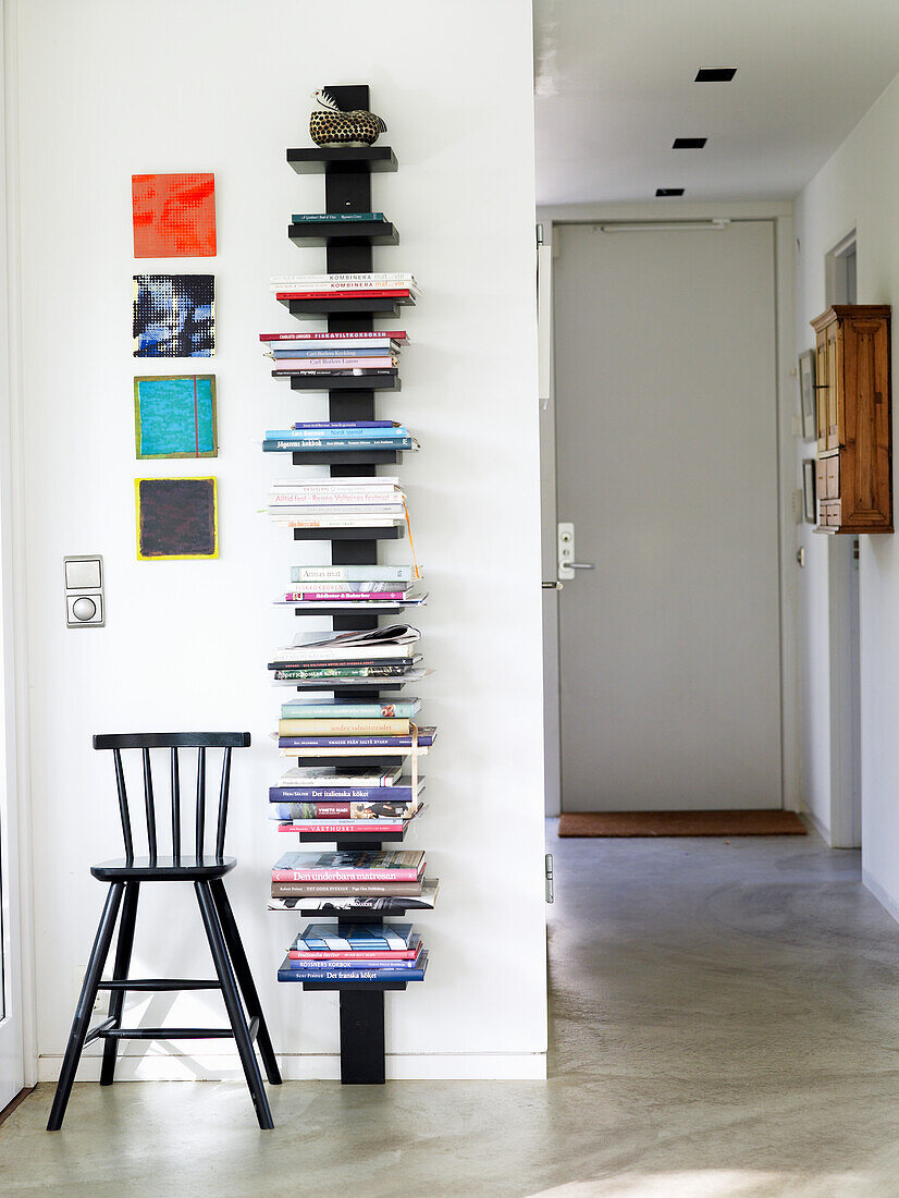Wall-mounted bookshelf with chair in minimalist hallway