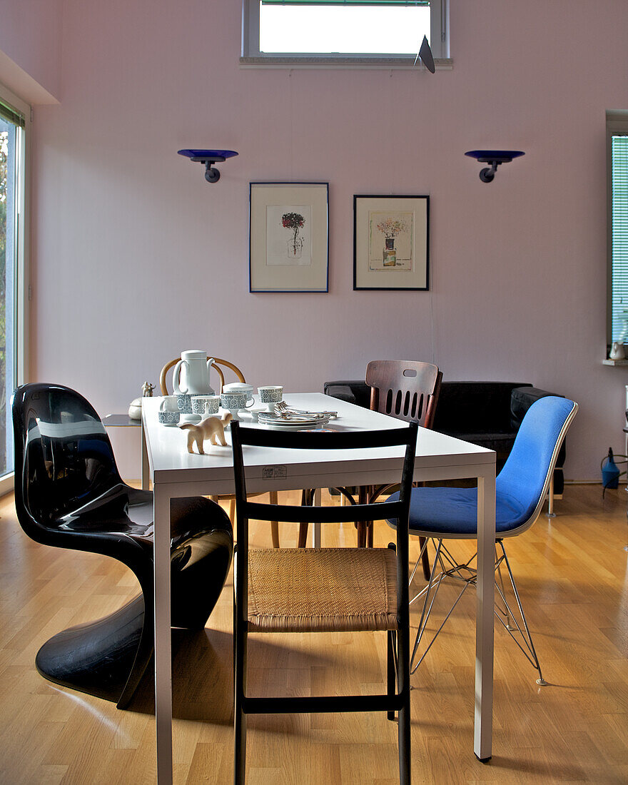 Dining area with various chairs and art on the wall