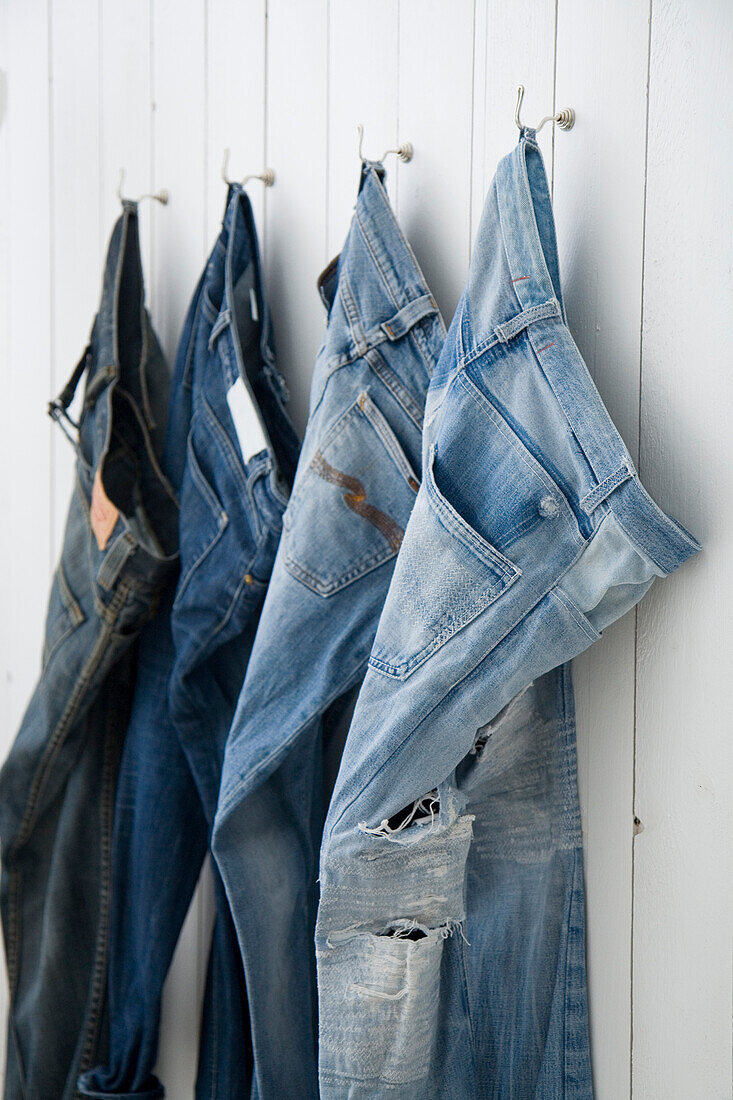 Denim trousers on wall hooks in the hallway or changing room