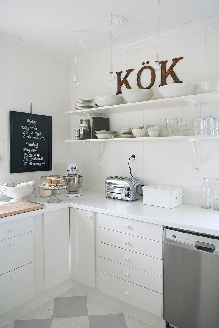 Weiße Landhausküche mit Tafel und "KÖK"-Schriftzug