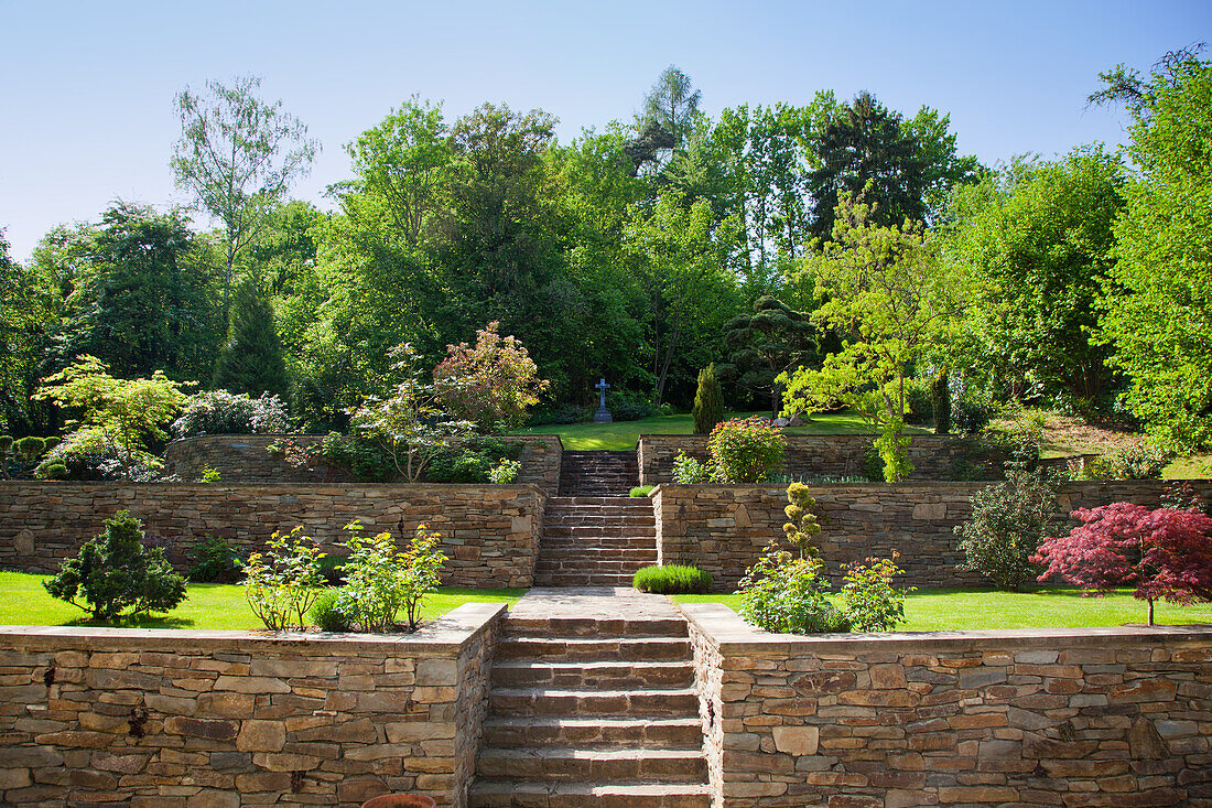 Well-kept garden with stone walls and staircase in summer