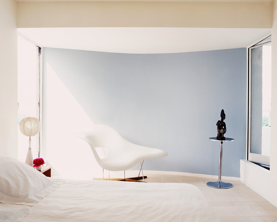 Weisses minimalistisches Schlafzimmer mit Liegesessel im Bauhausstil