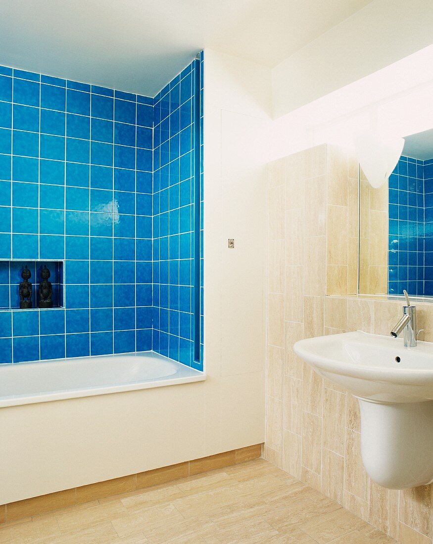 Modern bathroom with blue tiling around bathtub
