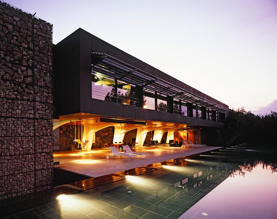 Modernes Haus mit großzügiger Terrasse und Pool in Abendstimmung