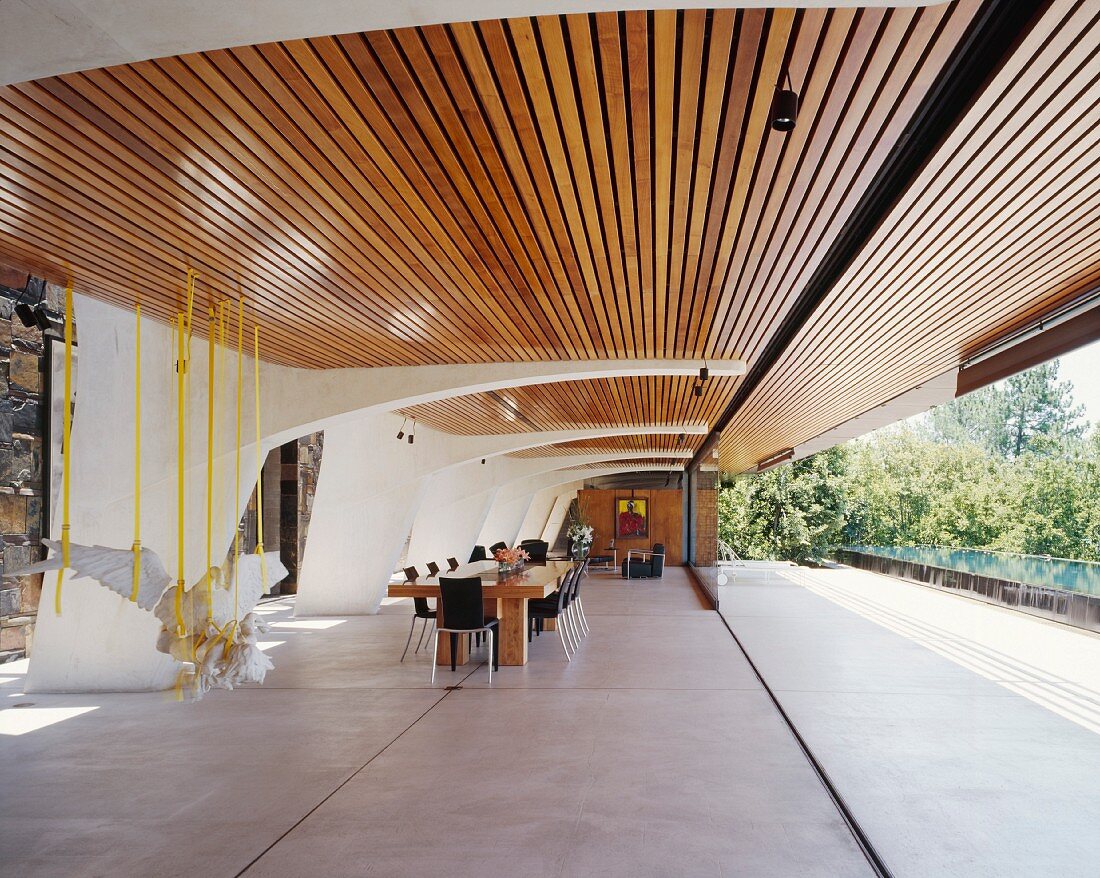 Überdachte Terrasse mit Holzjalousie dient als Ess- und Wohnraum