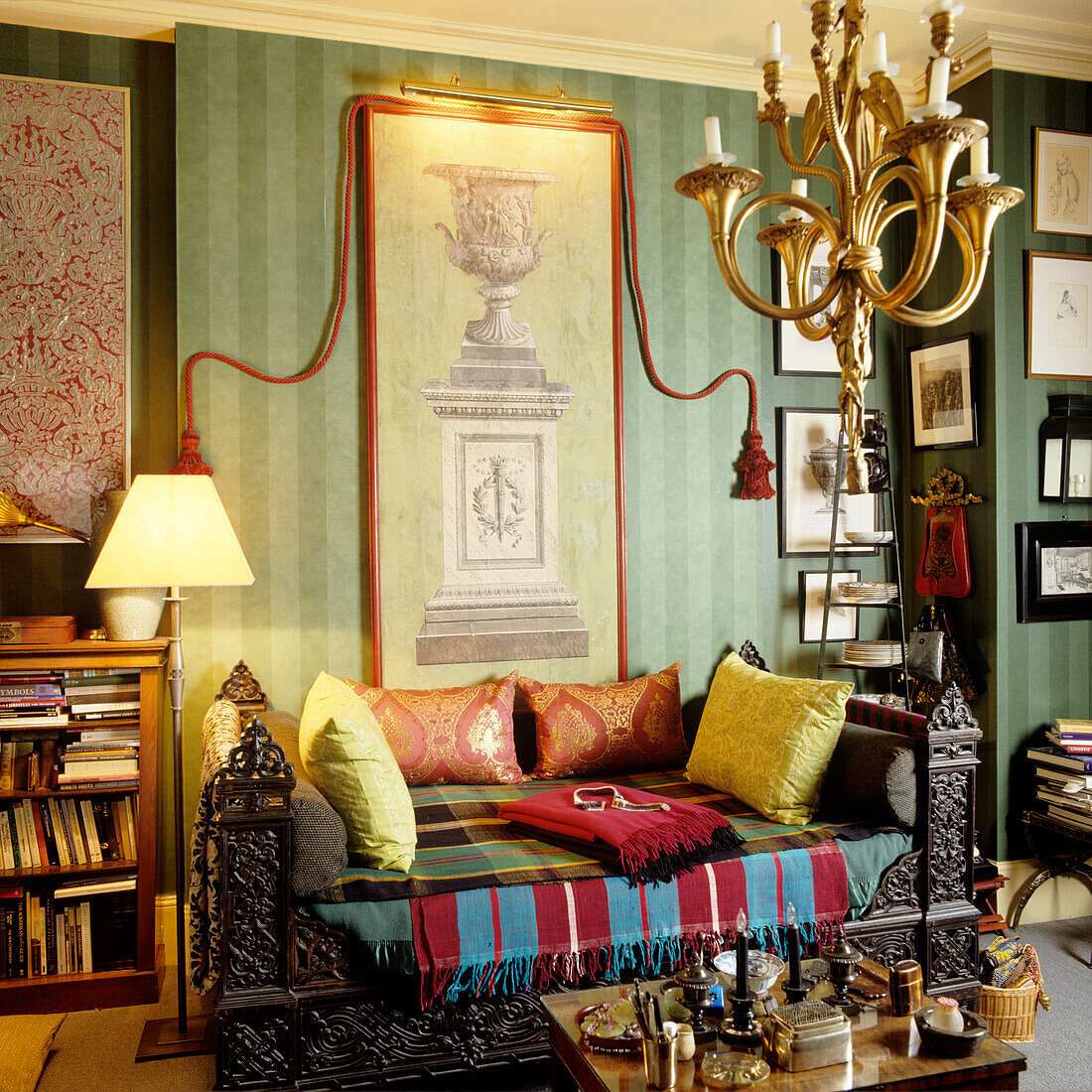 Living room with green striped wallpaper, antique furniture and colorful textiles
