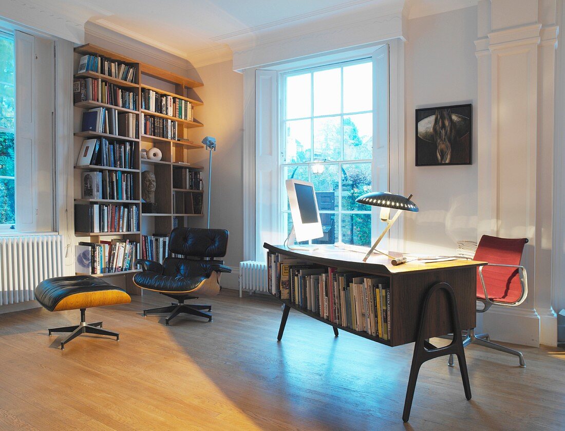 Ein Arbeitszimmer mit Bücherregal und Ledersessel