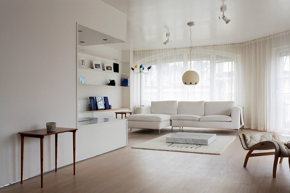 Open-plan living space with fitted shelving and upholstered sofa