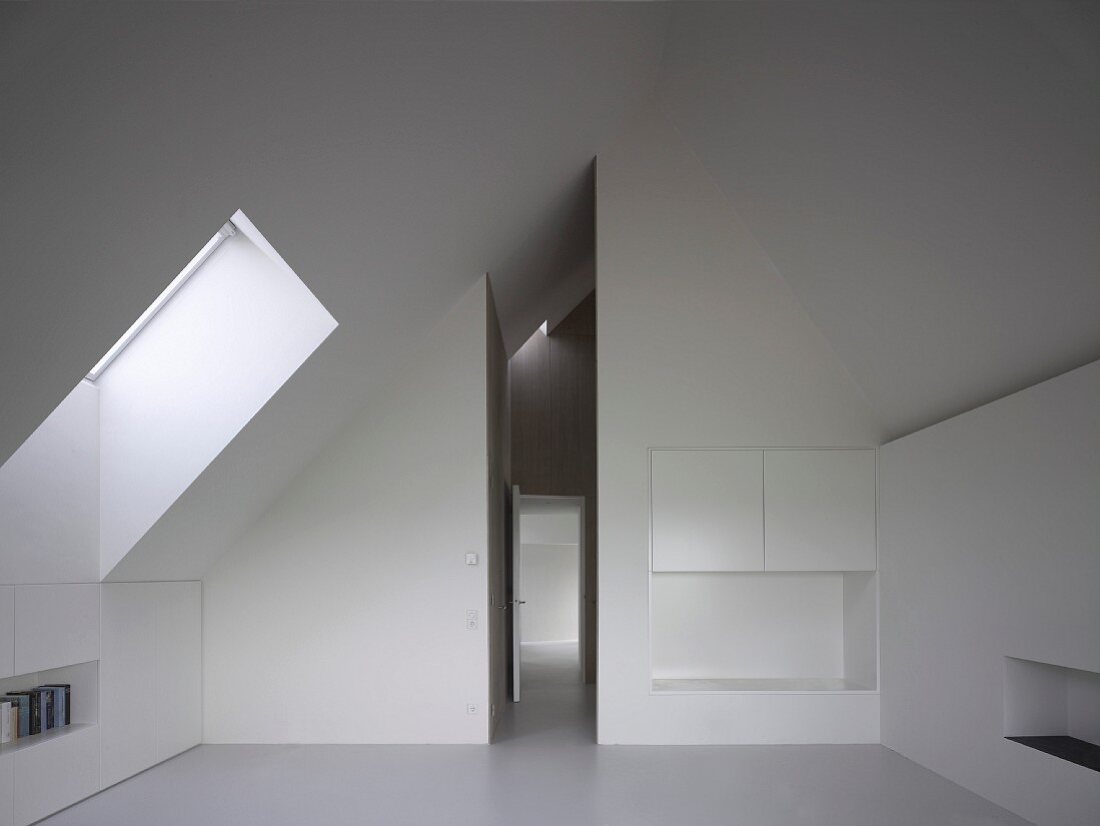 Fitted cupboards in white, modern attic room and view along narrow, high corridor with open door