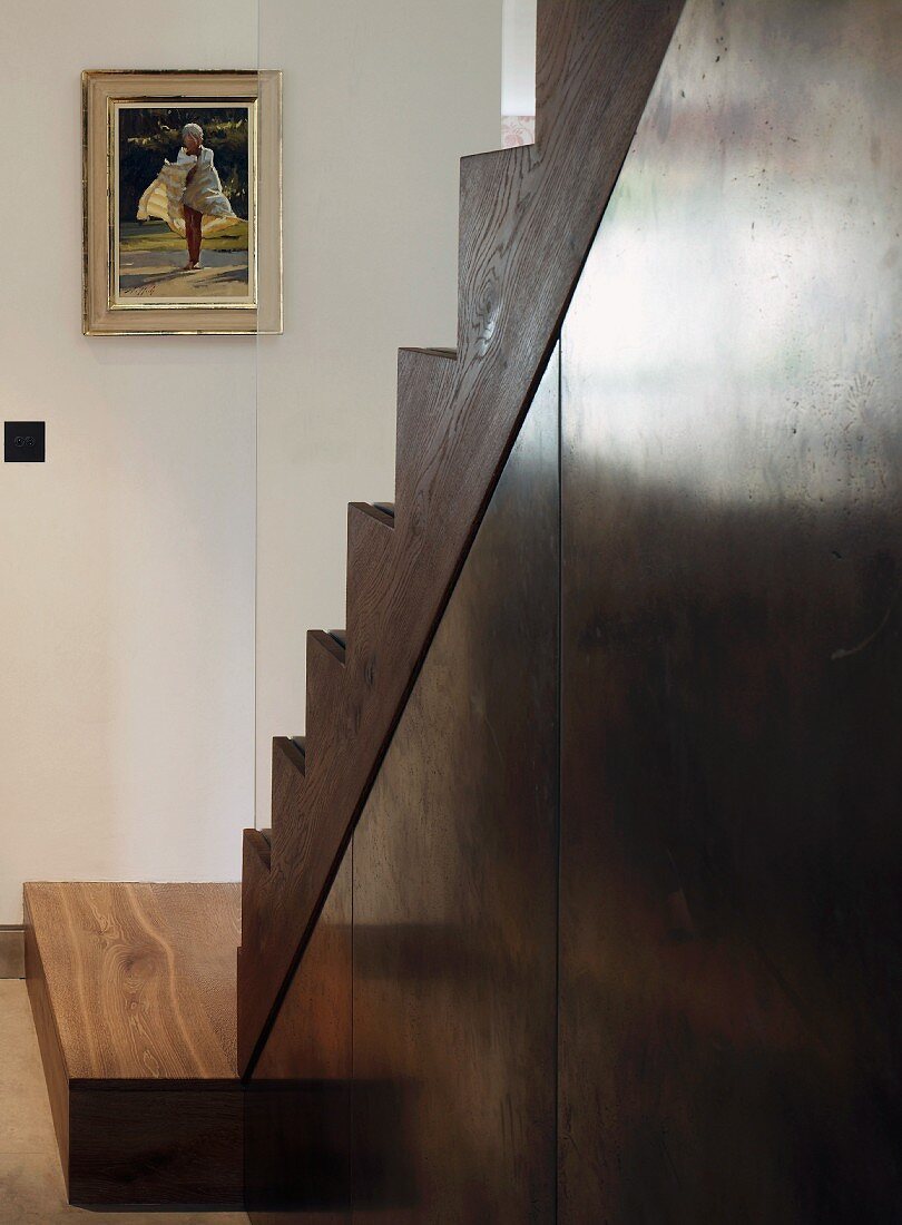 Open living room staircase - sheet metal below wood-clad treads with plate glass balustrade
