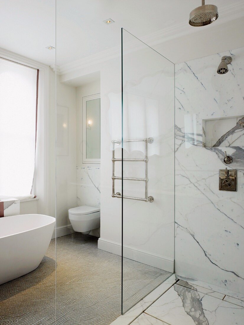 Freistehende Badewanne, Handtuchstangen und bodengleiche Dusche mit expressiver Marmorverkleidung