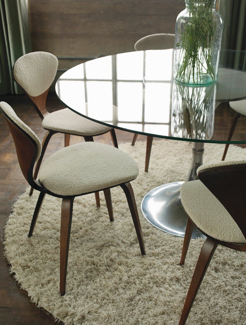 Glastisch mit Stühlen auf einem runden Tisch