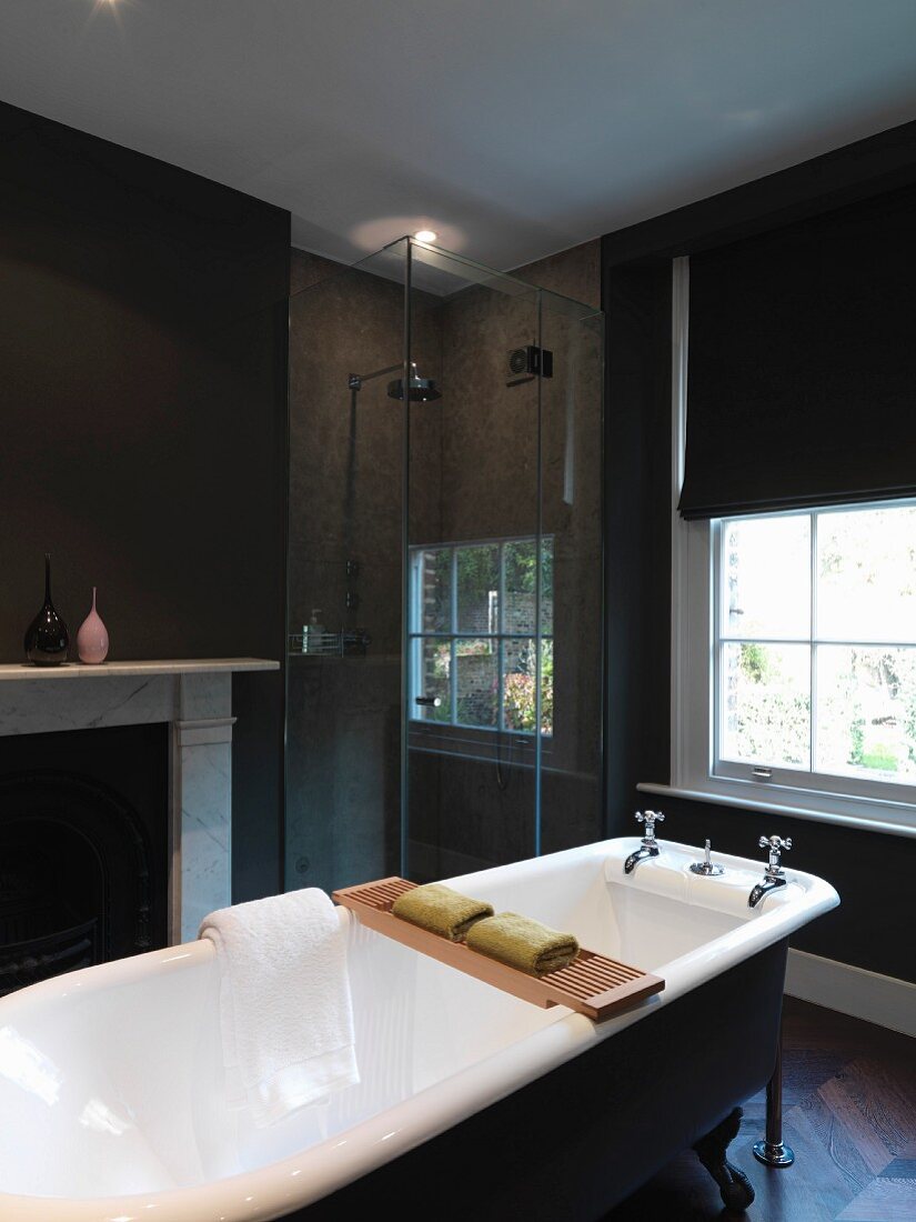 Free-standing bathtub in front of fireplace