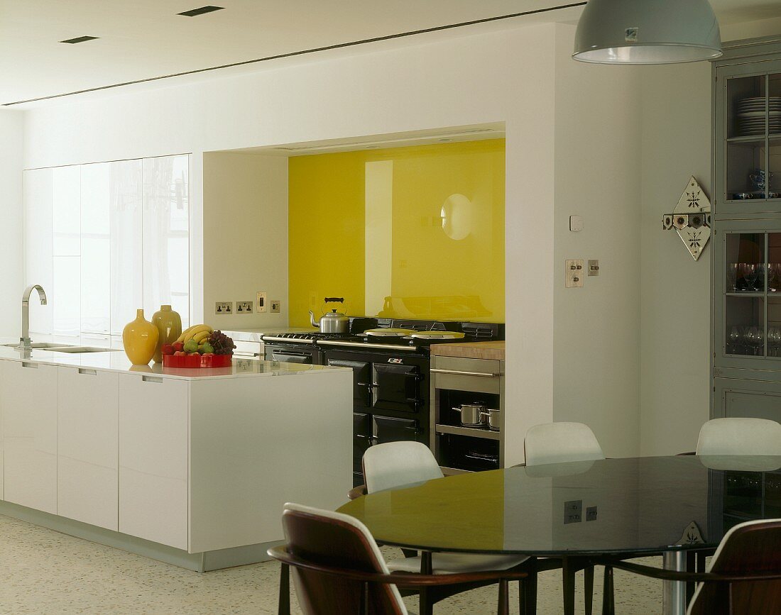 Offene Küche mit gelber Glaswand & Essplatz