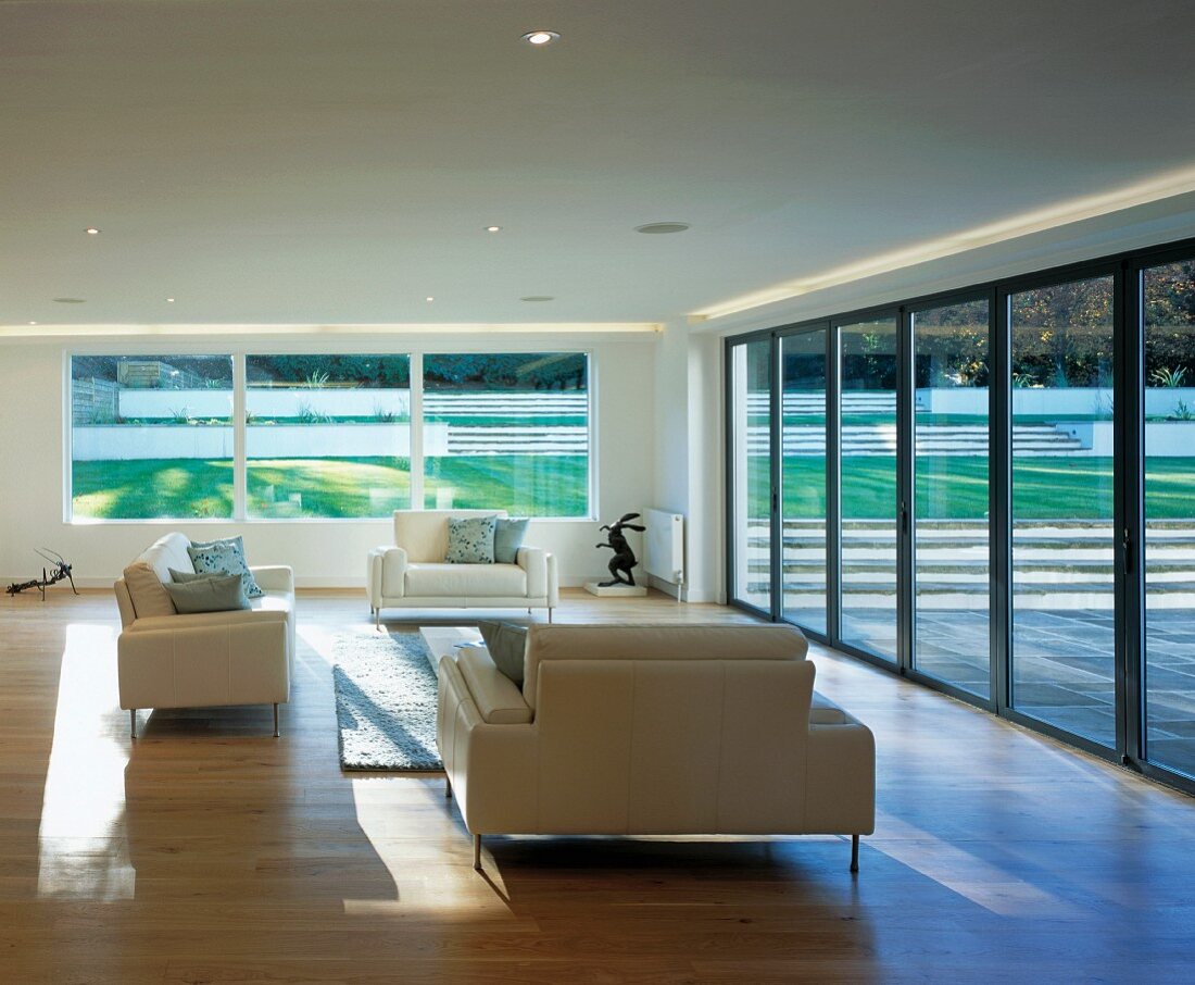 Living room with sofas, large windows & terrace doors