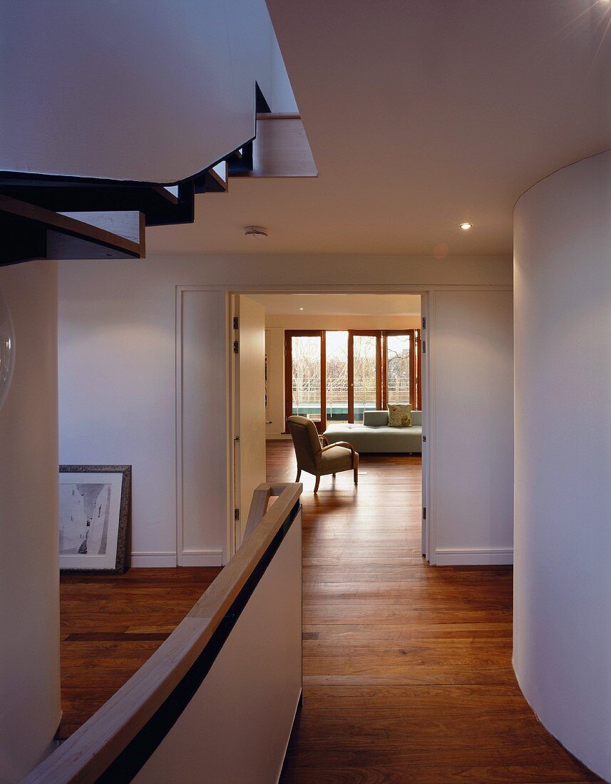 Blick vom Flur & Treppenhaus in Wohnraum mit Sofa & Sessel