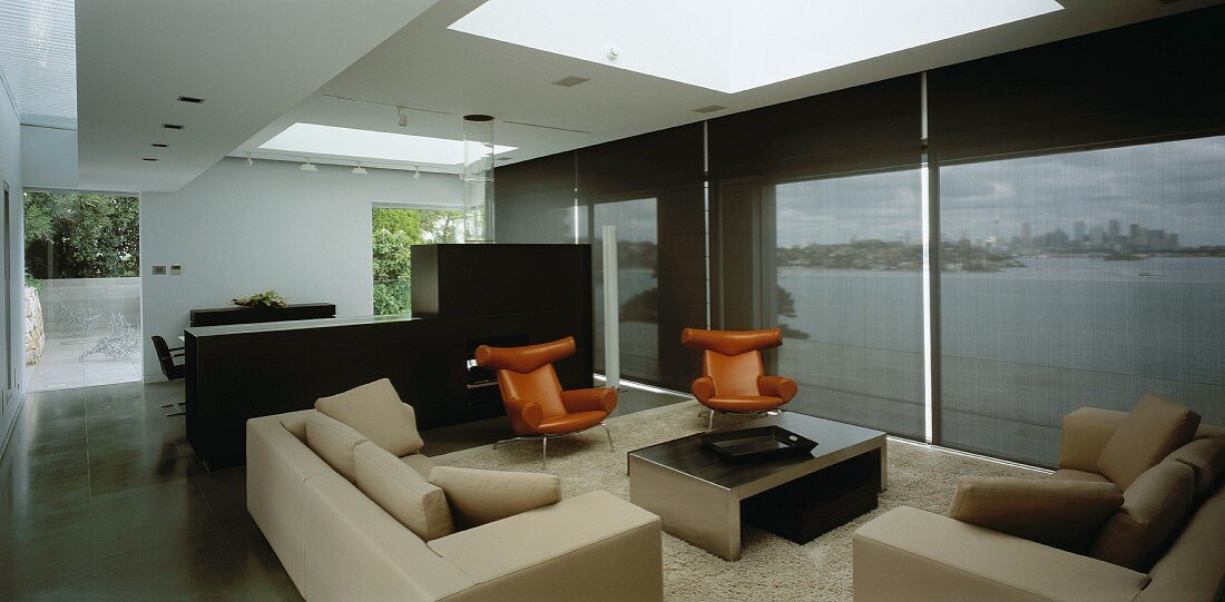 Offener Wohnraum mit Sofagarnitur, Sesseln & Raumteiler