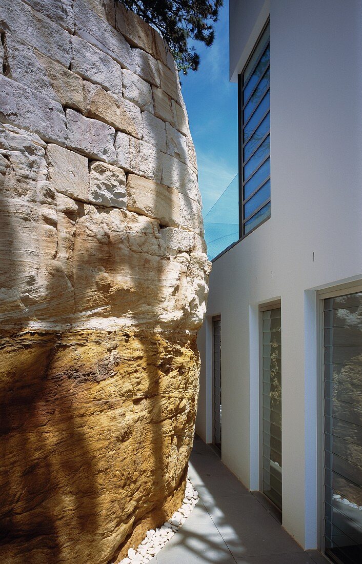 Modernes Wohnhaus neben alter Steinmauer