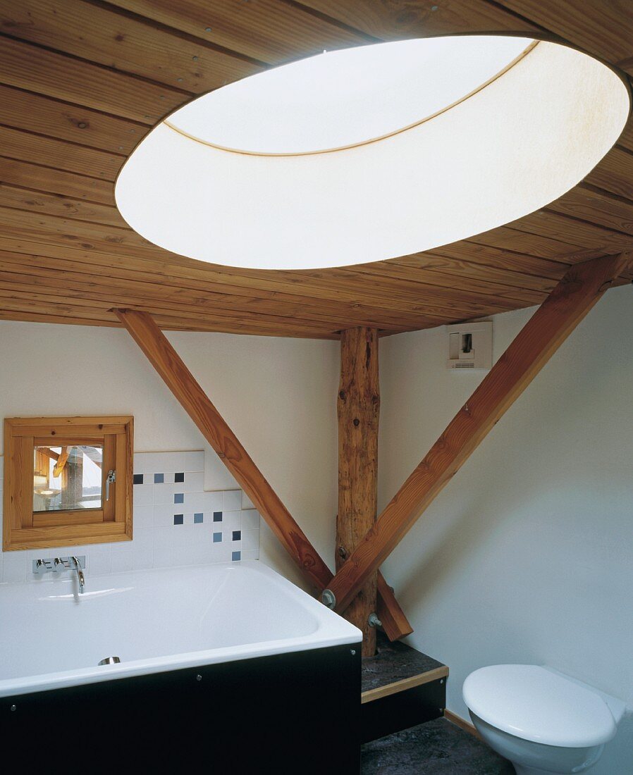 Bad mit Holzdecke, Holzbalken & rundem Deckenfenster