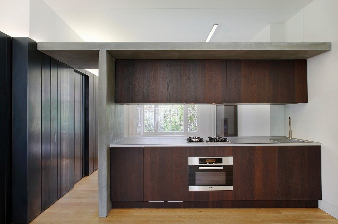 Dark wood kitchen in room with steel-clad walls