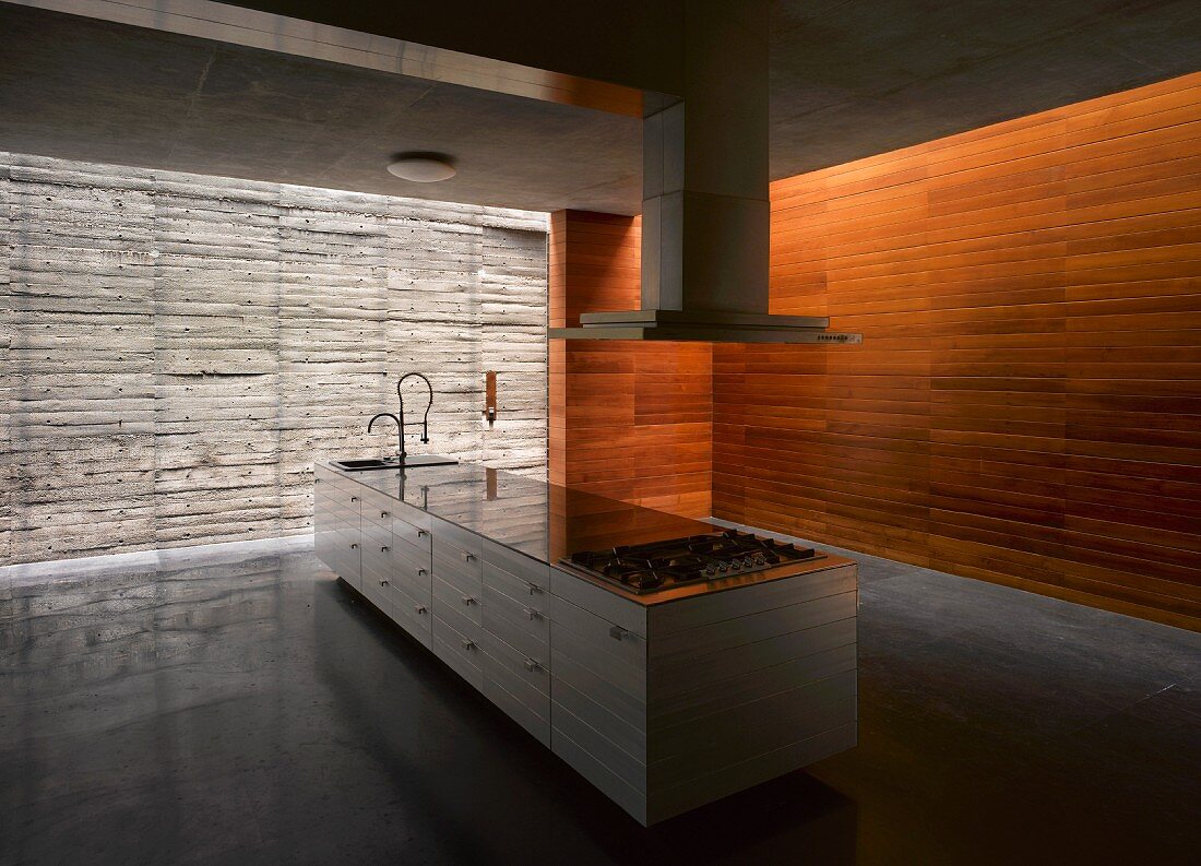 Schlichte Kücheninsel in großem Raum mit Beton- & Holzwänden
