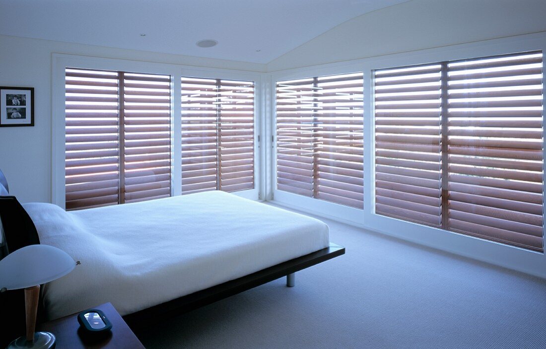 Bedroom with large windows and blinds
