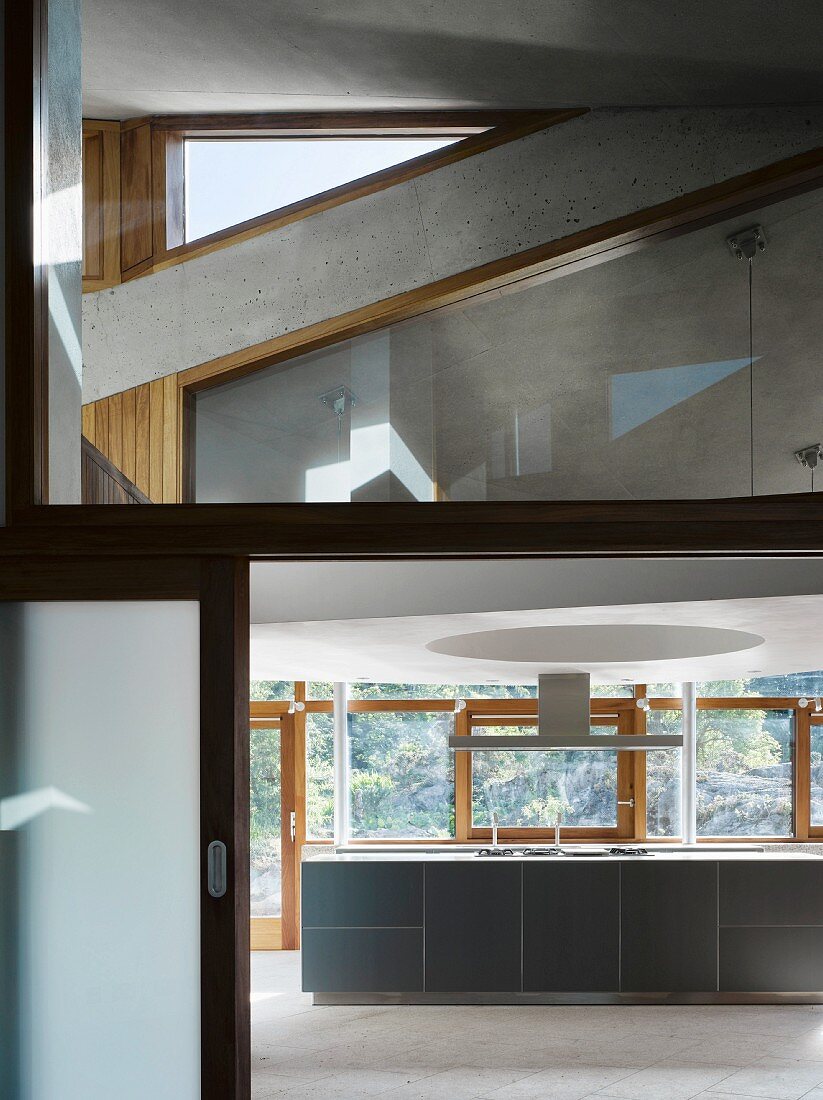 Contemporary building with view of kitchen units below window through open sliding door