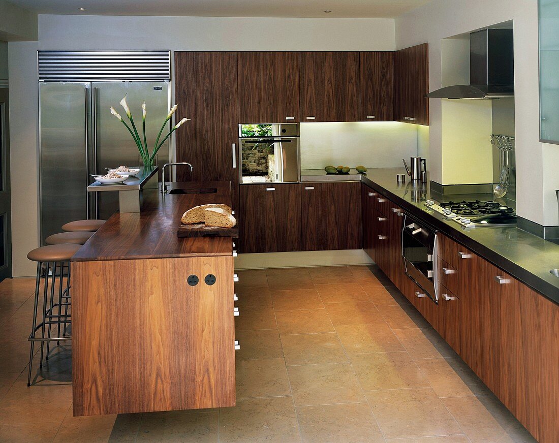 Open-plan designer kitchen with free-standing island and walnut fronts