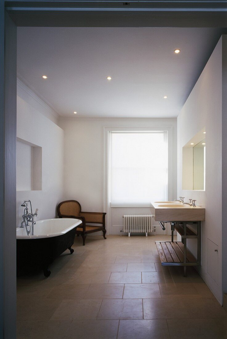 Vintage bathtub and modern washstand in renovated bathroom