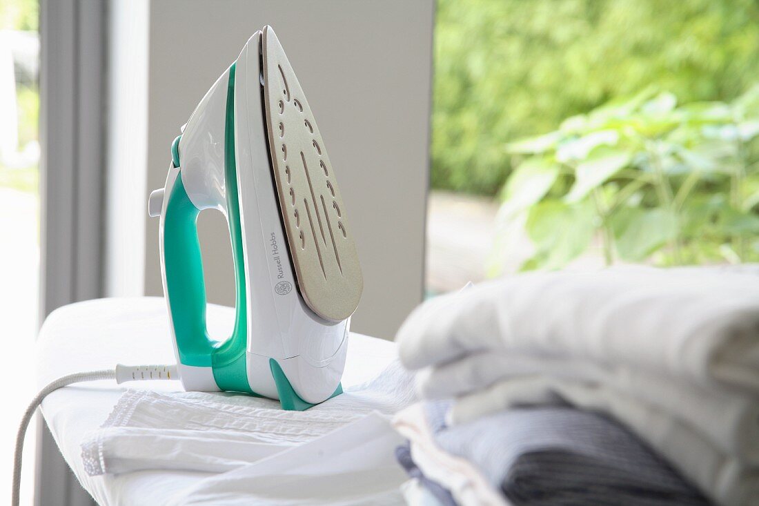 Iron and laundry on ironing board