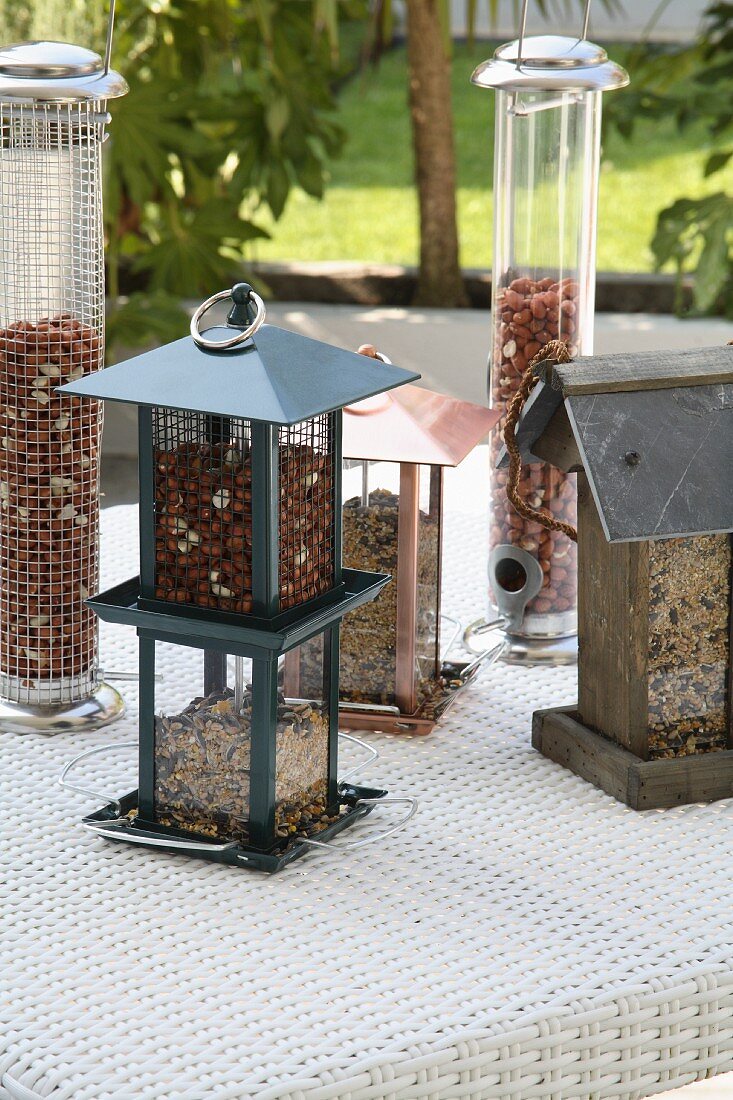 Vogelhäuschen mit Futter und Vogelfutter-Station auf einem Tisch
