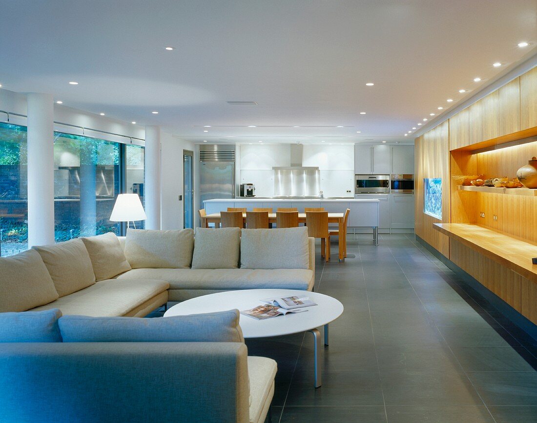 Open-plan living space with light sofas in front of dining area