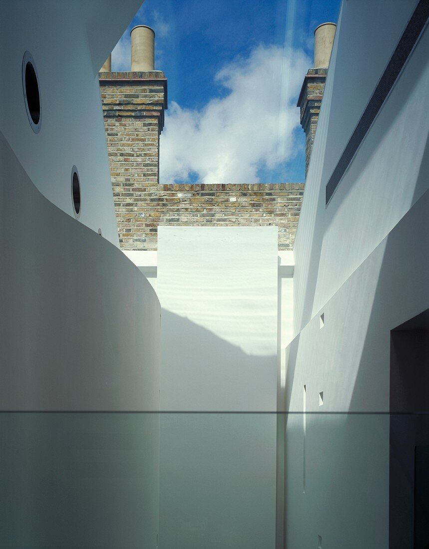 Blick in Innenhof einer zeitgenössischen Architektur vor Fabrik mit Ziegelfassade