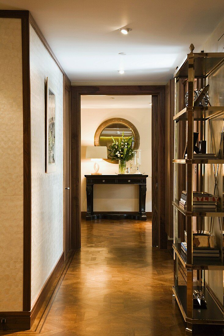 Chrome shelving in hallway and view of console table through ceiling-height door