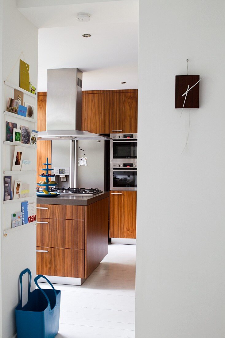 Blick durch raumhohen Durchgang in moderne Küche mit Holzfronten