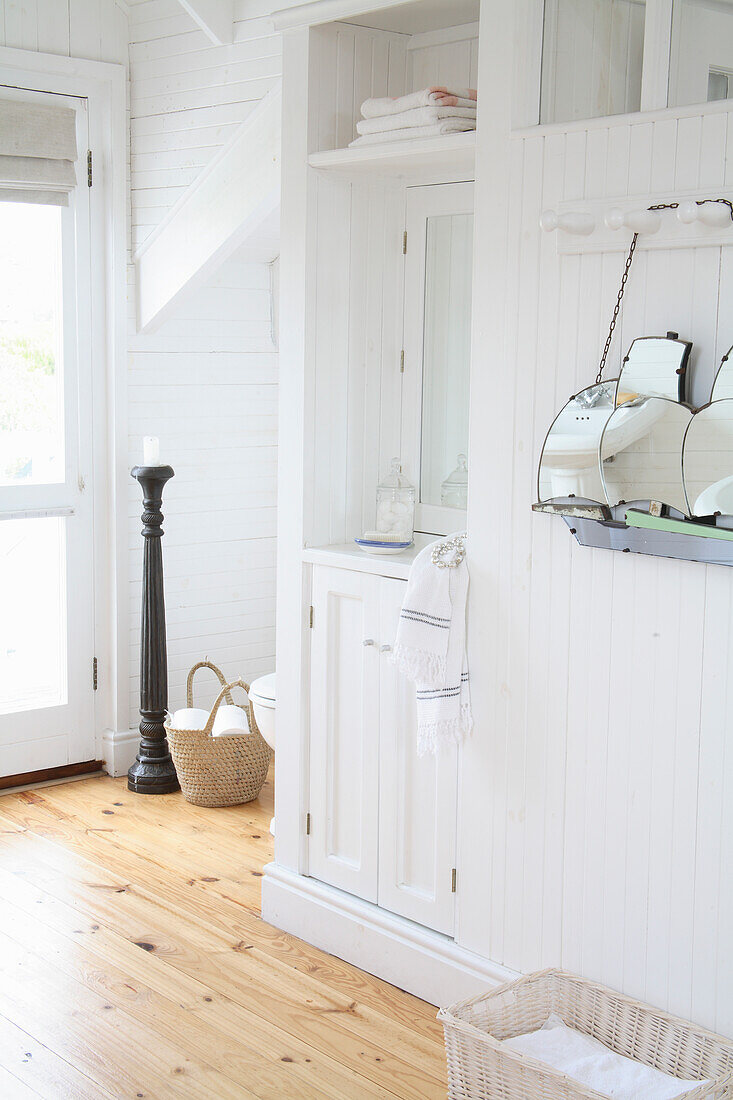 White wooden cabinets, baskets and wooden floor