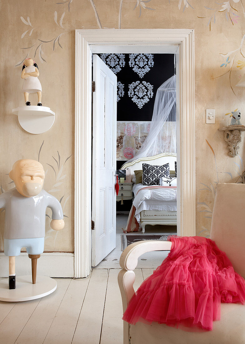 Kunstobjekte im Vorraum mit offener Tür und Blick in Schlafraum