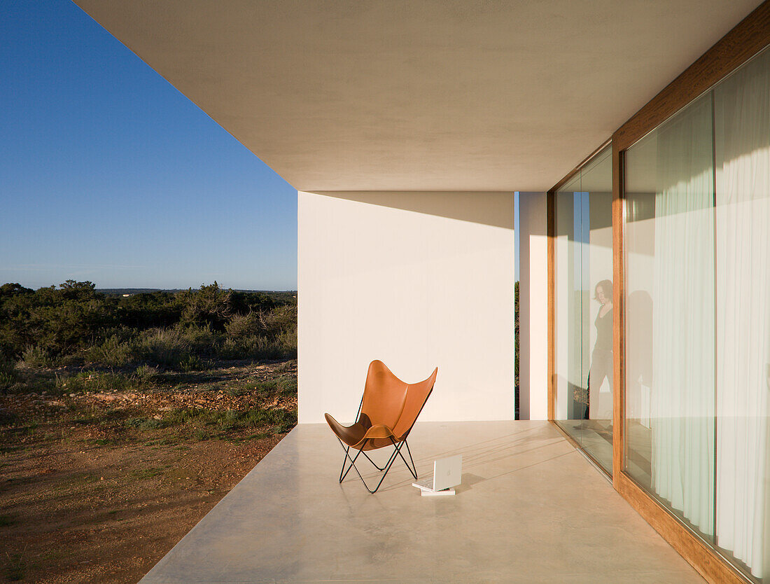 Moderne Terrasse mit Designerstuhl und Blick auf die Landschaft
