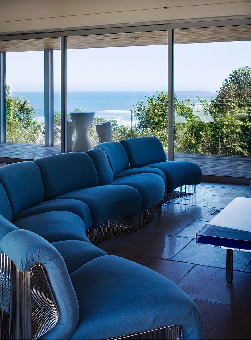 Blaue Sitzgarnitur in einem Wohnzimmer mit Meerblick