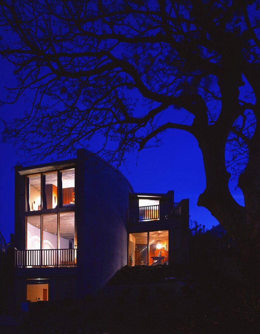 Illuminated house with floor-to-ceiling windows